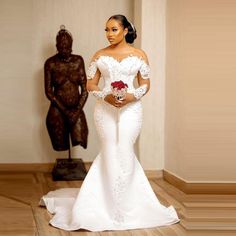 a woman in a wedding dress standing next to a statue