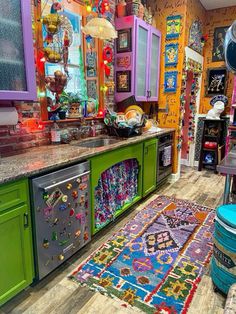 a brightly colored kitchen with lots of magnets on the cabinets and rug in front