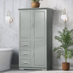 a white bath tub sitting next to a tall cabinet in a room with marble walls