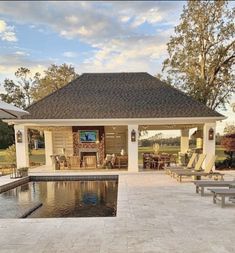 a pool house with lounge chairs around it