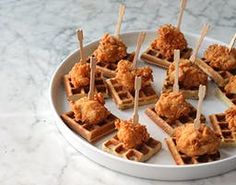 chicken and waffles are served with toothpicks on a white platter