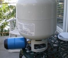 a large propane tank sitting on top of a patio table next to a window