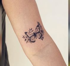 a woman's arm with a butterfly tattoo on the left side of her arm