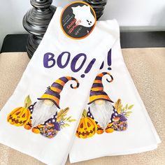 two white towels with witches and pumpkins on them, one has boo written on it