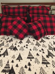 a bed topped with red and black plaid pillows