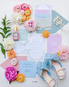 the wedding stationery is laid out with flowers