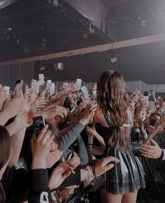 a group of people holding up their cell phones in front of them and taking pictures