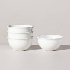 three white bowls are stacked on top of each other