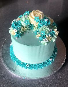 a cake with blue frosting and flowers on top