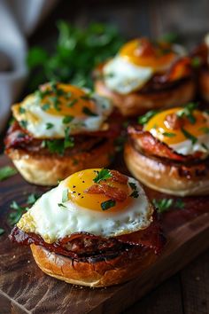 eggs and bacon on english muffins sitting on a cutting board with parsley