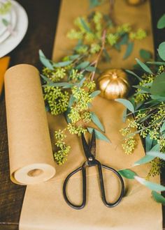 a pair of scissors sitting on top of a piece of paper next to some flowers