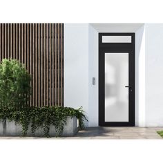 a black and white door is in front of a wall with green plants on it