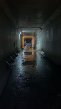 an empty dark tunnel with light at the end and no one in sight on the other side