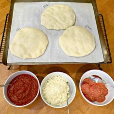 four different types of pizza dough in bowls on a baking sheet with measuring spoons