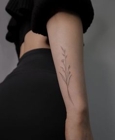 a woman's arm with a small flower tattoo on the left side of her right arm