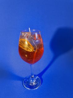 a wine glass filled with liquid on a blue background