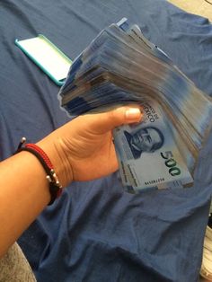 a person is holding stacks of money in their hand