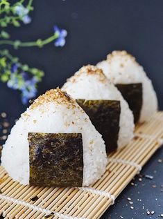 three pieces of sushi sitting on top of a bamboo mat