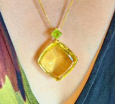 A Gold cocktail pendant features a large cushion cut 91.85 carats.  Natural earth mined Citrine.  The pendant has been hand crafted in 10K Yellow Gold, but only UK hallmark it as 9K.  It has been beautifully hand made to showcases this large gemstone with a square green Peridot in the bail.  Basket setting with simple lines combine with big bold gemstone, a classic design with contemporary looks. Only 1 is available.  Limited Edition.   Citrine Clarity - Transparent Citrine Colour - Sparkling Gr Cocktail Necklace, Peridot Color, Peridot Pendant, Citrine Pendant, Gold Cocktail, Ruby Pendant, Yellow Citrine, Red Gemstones, Green Peridot