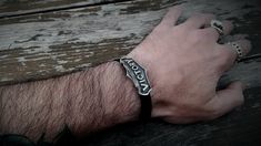 a man's arm wearing a bracelet with the word acrobat on it