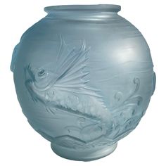 a glass vase with a fish design on it