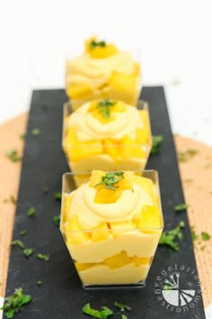 three small cups filled with food sitting on top of a black tray next to each other