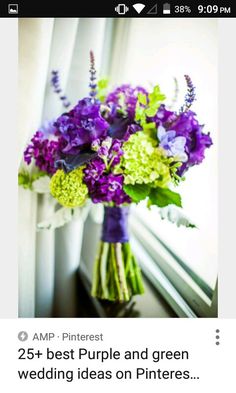 a bouquet of purple and green flowers on a window sill