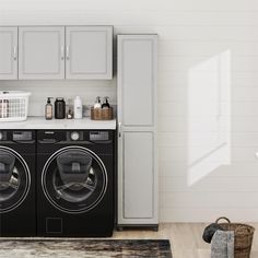 a washer and dryer in a room with white walls, wooden floors and cabinets