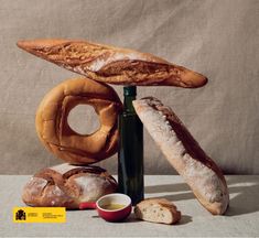 an assortment of breads and pastries are displayed on a table with a bottle