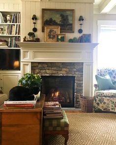 a living room filled with furniture and a fire place in the middle of a fireplace