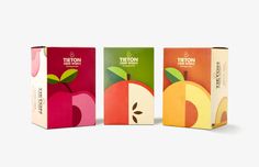 three boxes with different types of fruit on them, one is orange, the other is pink and green