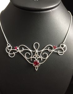 I love Victorian themed jewelry with an Edwardian, Elvish-inspired flair, and I hope I've captured it within this piece! I shall custom create this gorgeous Renaissance style necklace, in sterling silver, with three lab faceted Garnet gemstones. The center gemstone is 8mm round and the two sides are 4mm round. The chain will be soldered to each side and I will use a 1.2mm thick sterling box chain. I think this piece looks best near the collarbone area, so please measure the circumference of your Artisan Wire Wrapped Jewelry For Wedding, Artisan Wire Wrapped Wedding Jewelry, Fantasy Style Silver Jewelry With Unique Design, Red Artisan Jewelry For Wedding, Artisan Red Jewelry For Wedding, Red Handmade Jewelry For Wedding, Artistic Red Jewelry For Jewelry Making, Red Artistic Design Jewelry For Gift, Handmade Silver Fantasy Jewelry