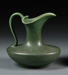 a large green vase with a curved handle