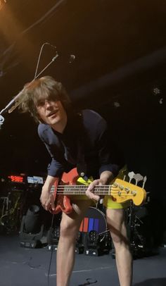 a young man playing a bass guitar on stage