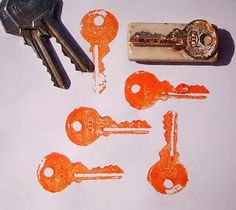 several keys are placed next to each other on a white surface with orange ink that has been drawn onto them