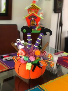 an arrangement of halloween decorations in a pumpkin shaped vase on a table with other items