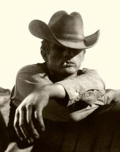 black and white photograph of a man wearing a cowboy hat with his hand on his hip