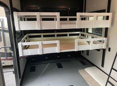 the interior of a camper with bunk beds and ladders on each side is shown