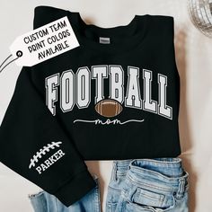 Black Personalized Football Mom Sweatshirt with Player's Custom Name, Football Mama Hoodie, Football Mom Hoodie with Son's Name Listing pricing is for one sleeve only. If you would like two names on two different sleeve, please visit: https://www.etsy.com/listing/1769663771/black-personalized-football-mom The Gildan 18000 sweatshirt is made from a heavy blend of cotton and polyester, making it perfect for any situation. The ribbed knit collar will keep your neck warm, and the garment is machine-washable, so you can be sure it will look fresh and beautiful even after repeated washes. Introducing the Ultimate Comfort Unisex Heavy Blend Hooded Sweatshirt. Looking for a sweater that will keep you warm and comfortable? Our unisex heavy blend hooded sweatshirt is the answer to your needs. Made w Football Mom Outfits, Football Mom Outfit, Plush Making, Football Hoodies, Mom Crewneck, Football Sweater, Mama Hoodie, Football Theme, Boo Shirts