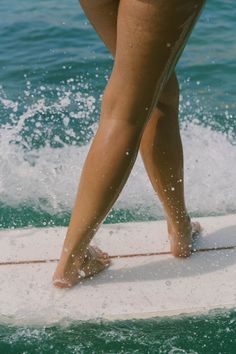 a person standing on a surfboard in the ocean with water splashing around them