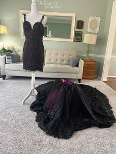 a dress on display in a living room next to a mirror and couch with pillows