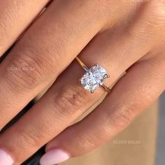 a woman's hand with a ring on her finger and a diamond in the middle