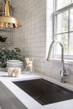 a kitchen sink with plates and cups on the counter