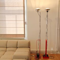 two lamps sitting next to each other on top of a hard wood floor in front of a window