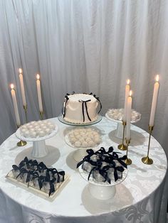 a white table topped with cakes and candles