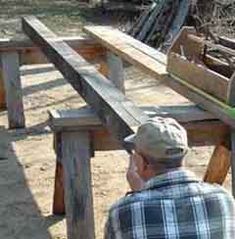 a man sitting at a picnic table with his skateboard on the bench next to him