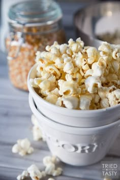 a white bowl filled with popcorn sitting on top of a table