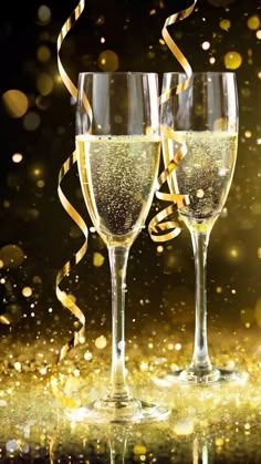 two champagne flutes with streamers and confetti in front of a gold background