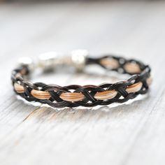 a braided bracelet is sitting on a wooden table