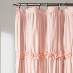 a pink curtain with flowers hanging from it's side